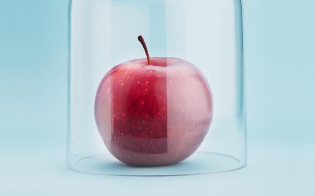 Een appel onder een glazen stolp.