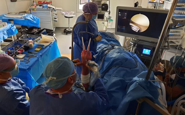 Foto van de chirurgische opstelling bij een polsartroscopie. De patiënt ligt op de rug, met de arm onder tractie.