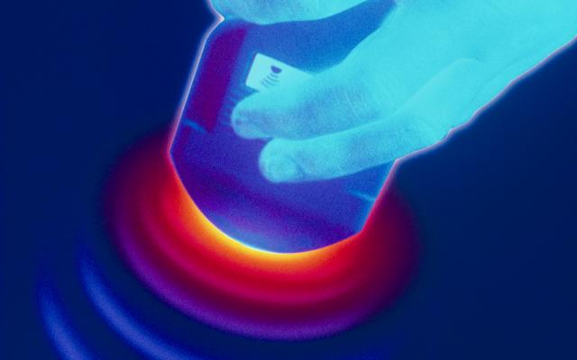 Een hand houdt een echoapparaat vast.