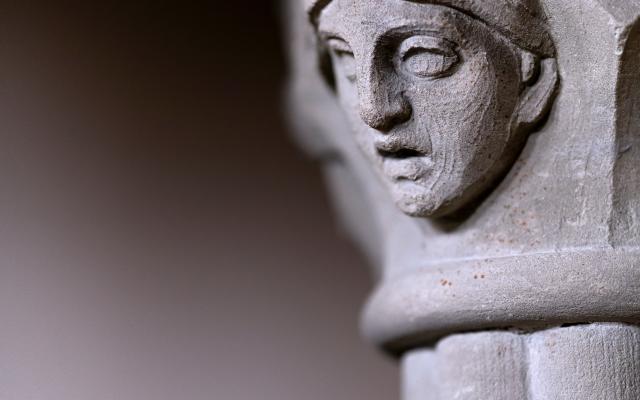 Een stenen zuil waar een gezicht in is gehouwen.