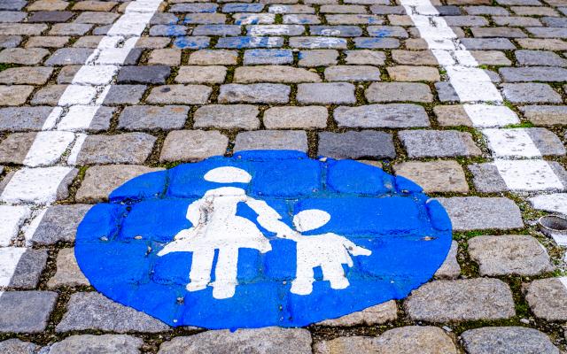 Blauw-wit icoon van een moeder met kind. Het icoon is geverfd op straattegels.