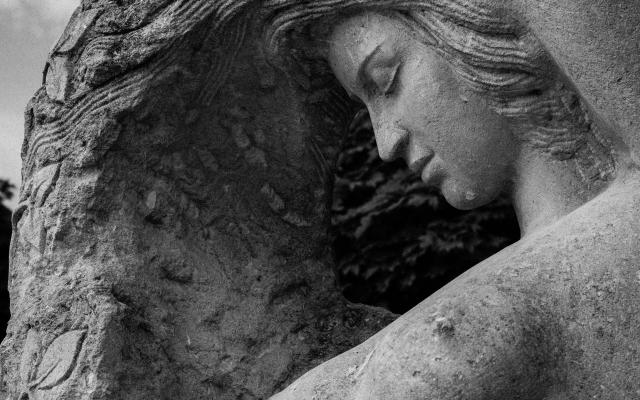 Stenen beeld van een naakte vrouw.