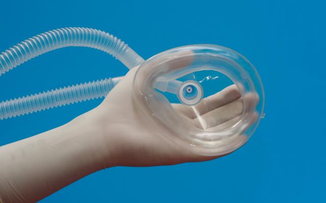 Een kinderhand houdt een zuurstofmasker vast.