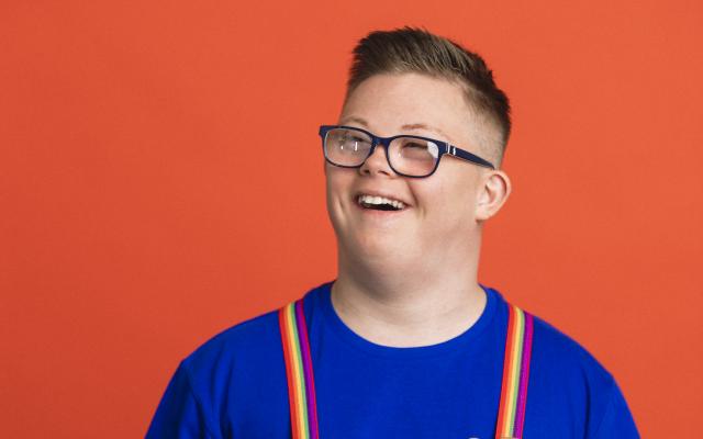 Een jongen met bretels aan.