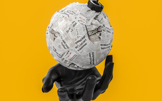 In een zwarte handschoen ligt een bom gewikkeld in kranten.