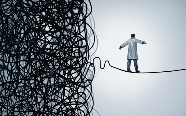 Een arts balanceert op een getekende lijn uit een massa zwarte krabbels.