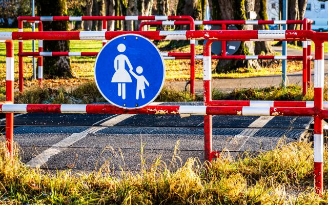 Een hek met een verkeersbord met moeder met kind