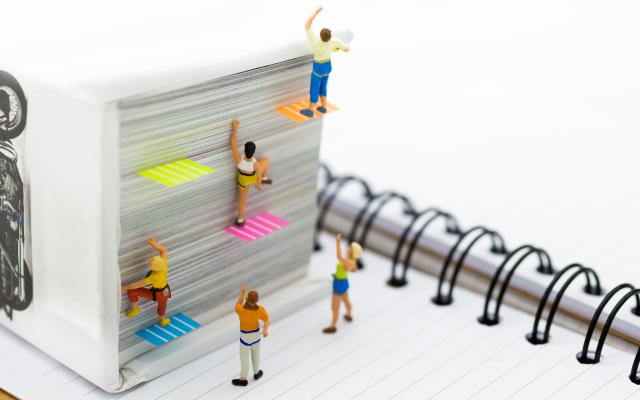 Poppetjes die tegen een muur van papier opklimmen