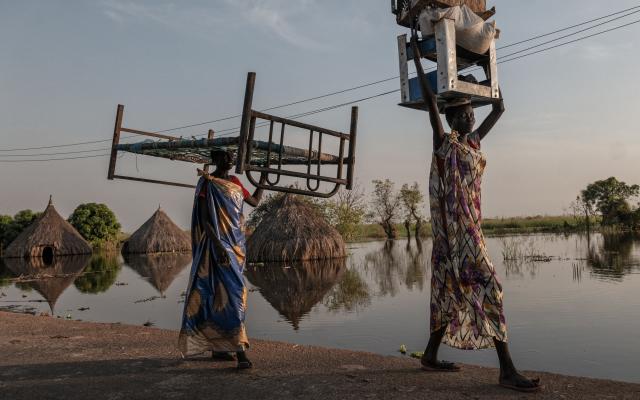 Afrikaanse vrouwen die hun hebben en houden op het hoofd dragen