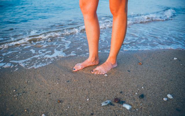 Blote voeten in de branding van de zee