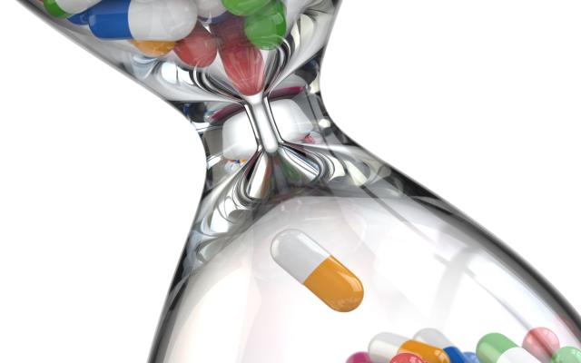 Een zandloper waar pillen doorheen stromen