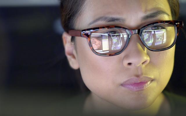 Een vrouw die op een beeldscherm kijkt