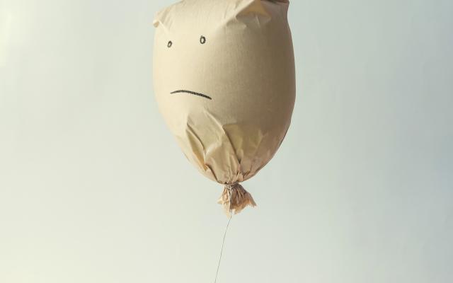 Ballon met ongelukkige smiley erop