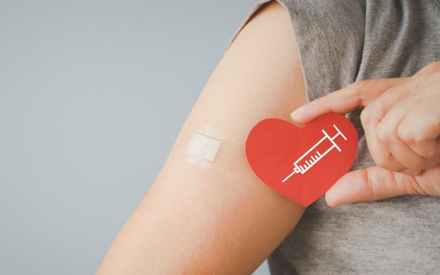 Gevaccineerde arm met daarbij een hartje met daarop een injectiespuit 