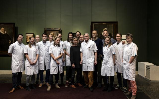 Groepsfoto medici met schilderijen op de achtergrond