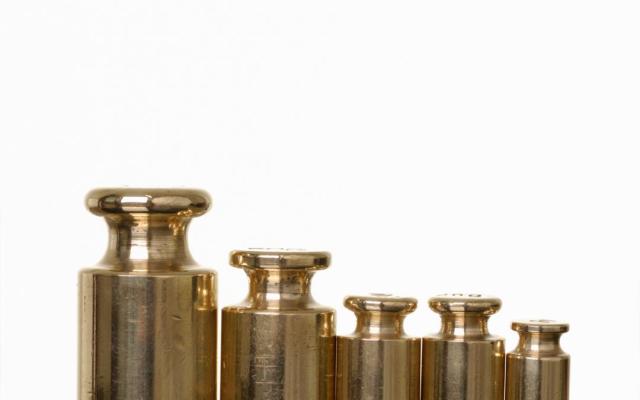 Een set weegschaalgewichten op een rij van groot naar klein.