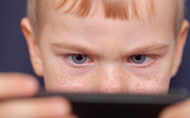 Jongen staart naar telefoon