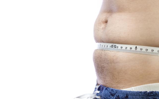 Een blote buik met meetlint eromheen