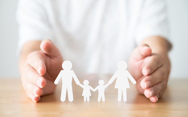 Handen die een gezin beschermen