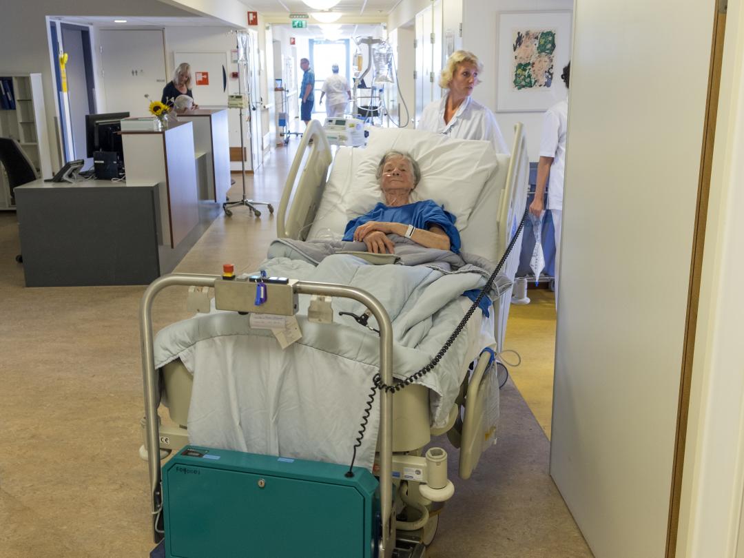 Een oudere patiënt in een ziekenhuisbed.