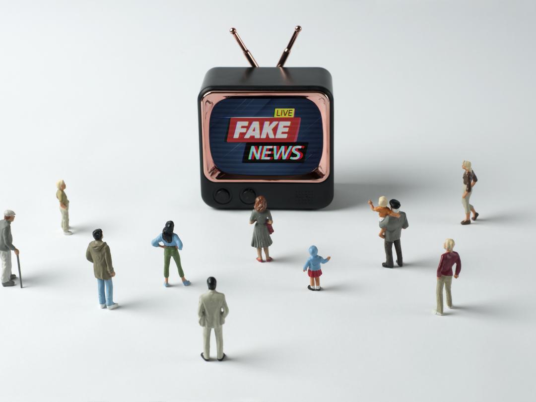 Kleine miniatuur tv met miniatuurfiguren eromheen.