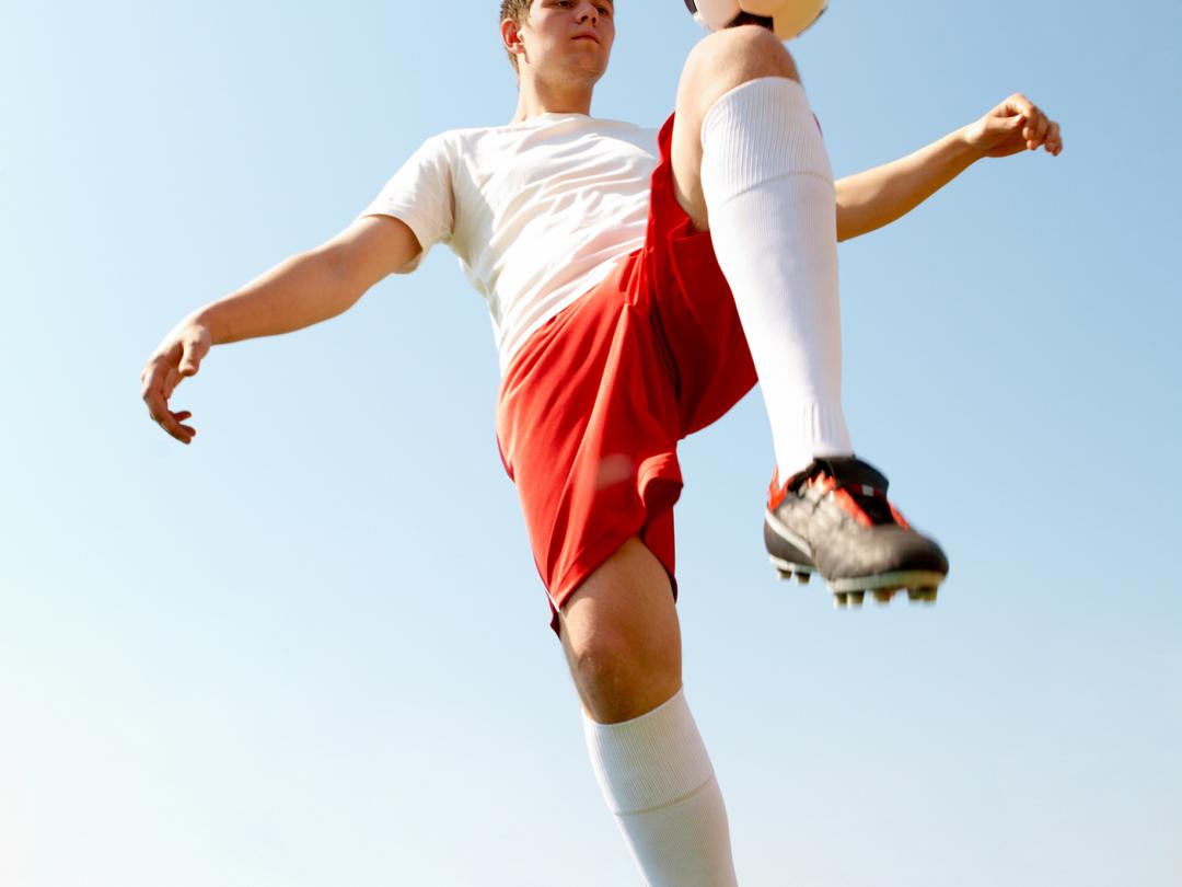 Kind met voetbal op de knie