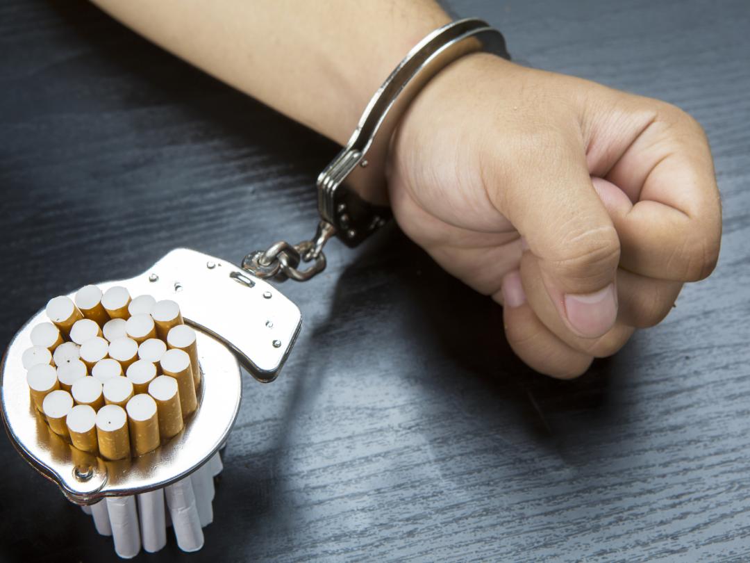 Hand en Sigaretten vast in handboeien