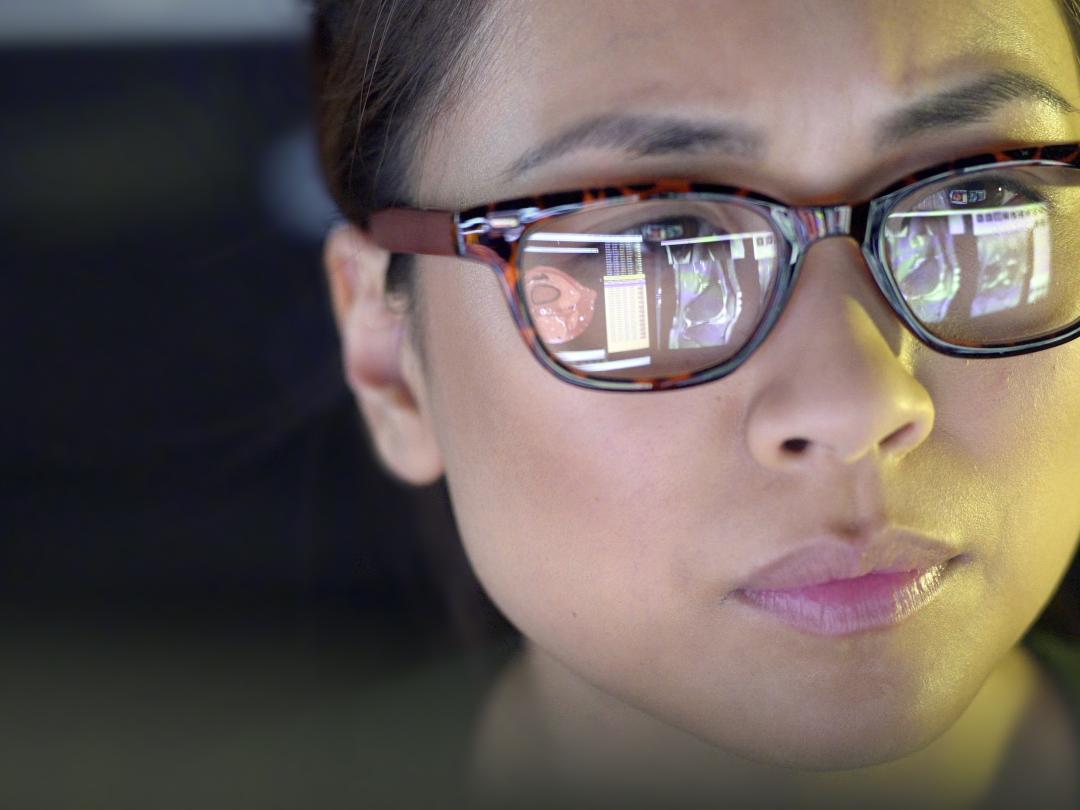 Een vrouw die op een beeldscherm kijkt