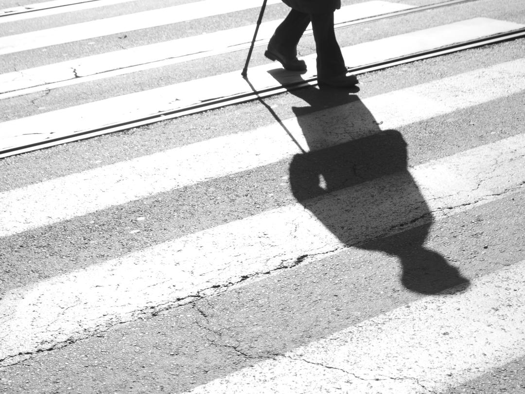 Een schaduw van een lopend iemand op een zebrapad