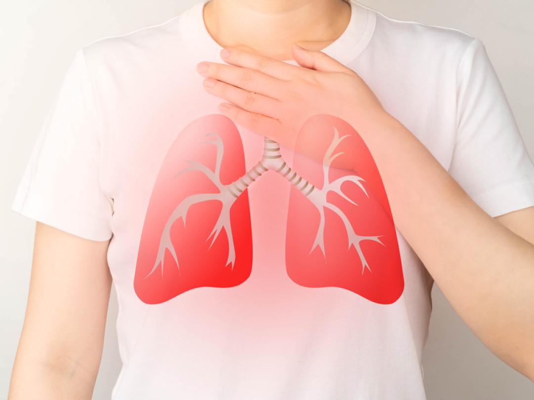 Iemand met wit T-shirt met rode longen erop