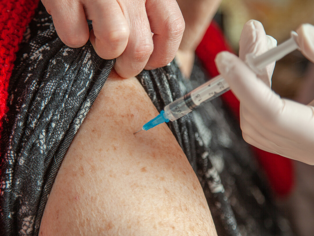 Iemand die een prik krijgt in de bovenarm