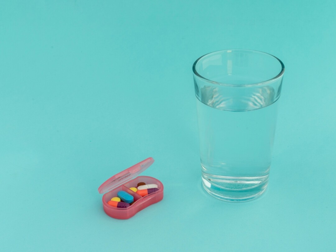 Glas water met een pillendoosje