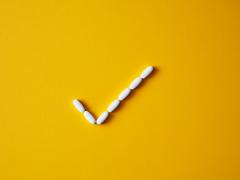 Een aantal pillen is neergelegd in de vorm van een vinkje.