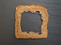 Een bruine boterham waaruit het middelste deel ontbreekt.