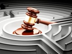 Een voorzittershamer geplaatst in het midden van een doolhof.