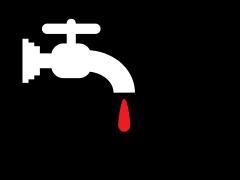 Een kraan waar een rode druppel uit valt