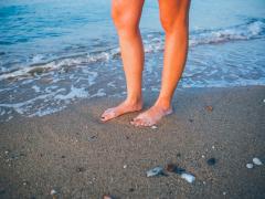 Blote voeten in de branding van de zee