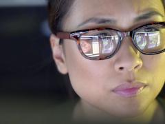 Een vrouw die op een beeldscherm kijkt