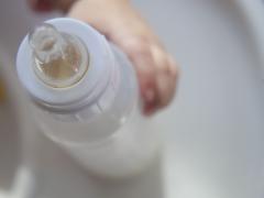 Baby die een flesje vasthoudt