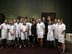 Groepsfoto medici met schilderijen op de achtergrond