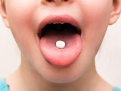 Een uitgestoken tong met een pil erop