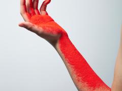 Foto van een arm met rode inkt