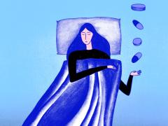 Een vrouw in bed die tabletten opvangt