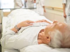 Oude man die in zieknhuisbed ligt