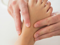 Een arts die een voet onderzoekt