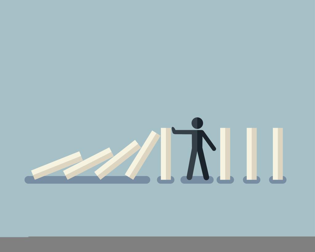 Een mannetje dat omvallende blokjes tegenhoudt